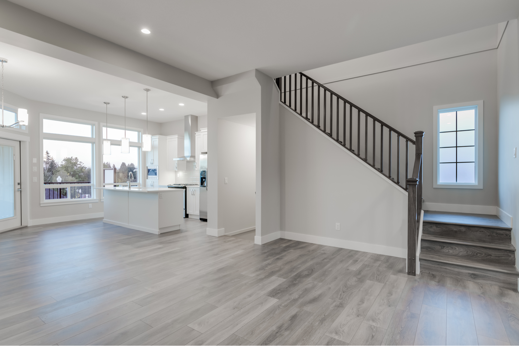 Room and staircase with grey wood floors