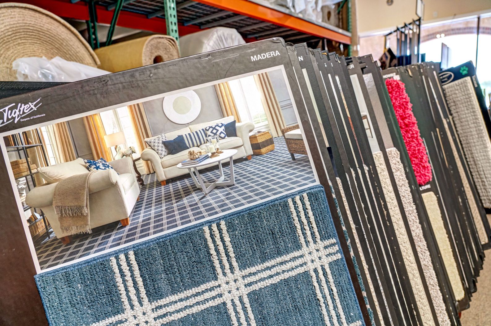 Display of statement carpets. The sample in the front is blue with white grid squares.